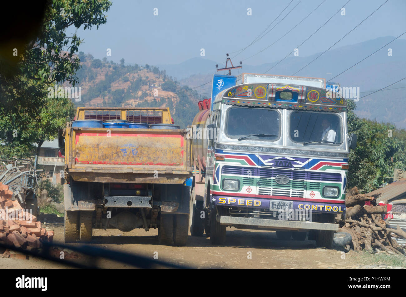 Autobús que pasaba por camión en un estrecho camino de tierra, Trishuli Valley, cerca de Katmandú, Nepal Foto de stock