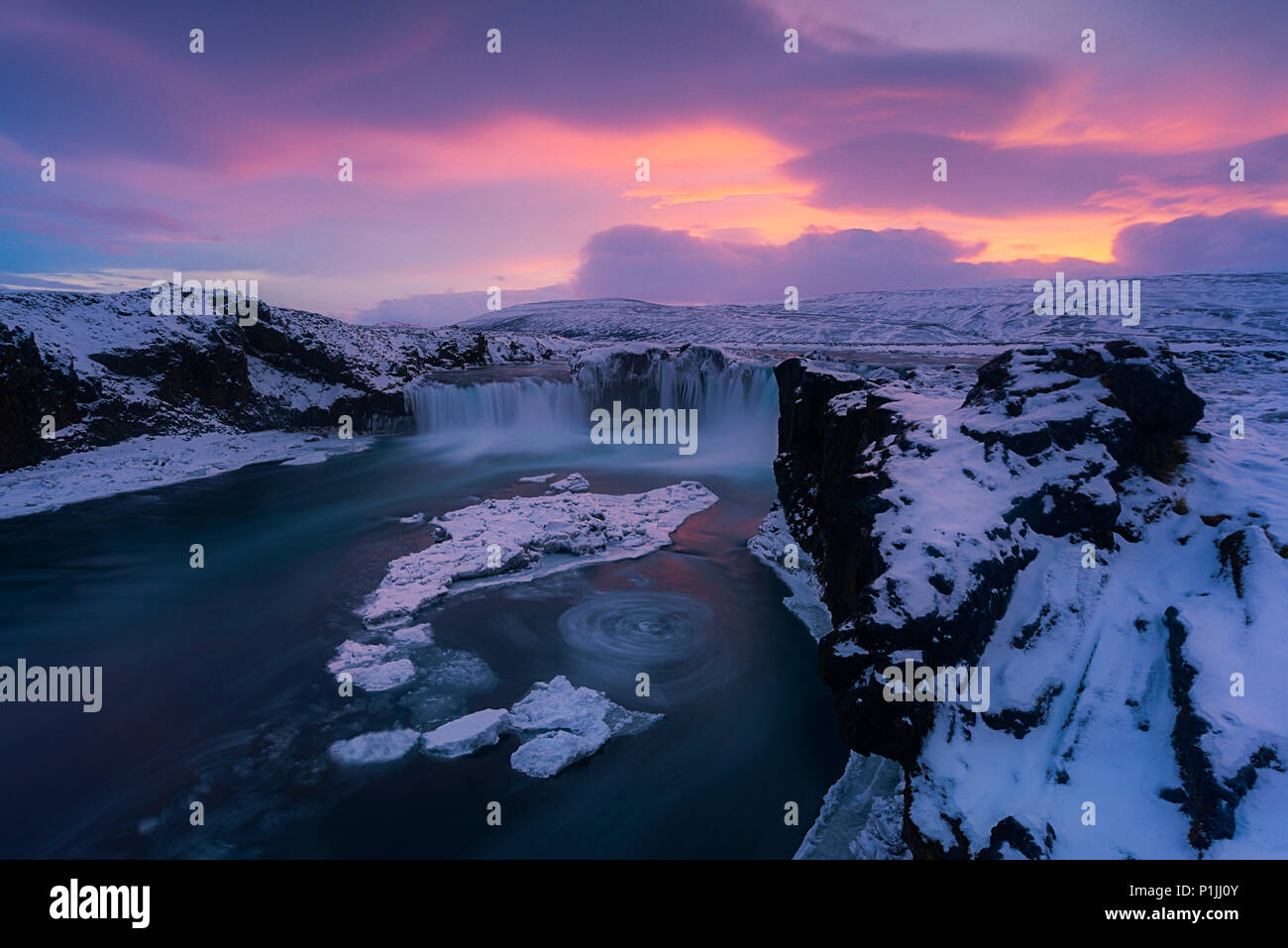 Atardecer en cascada Godafoss en hielo y nieve en invierno, Highlands, Islandia Foto de stock