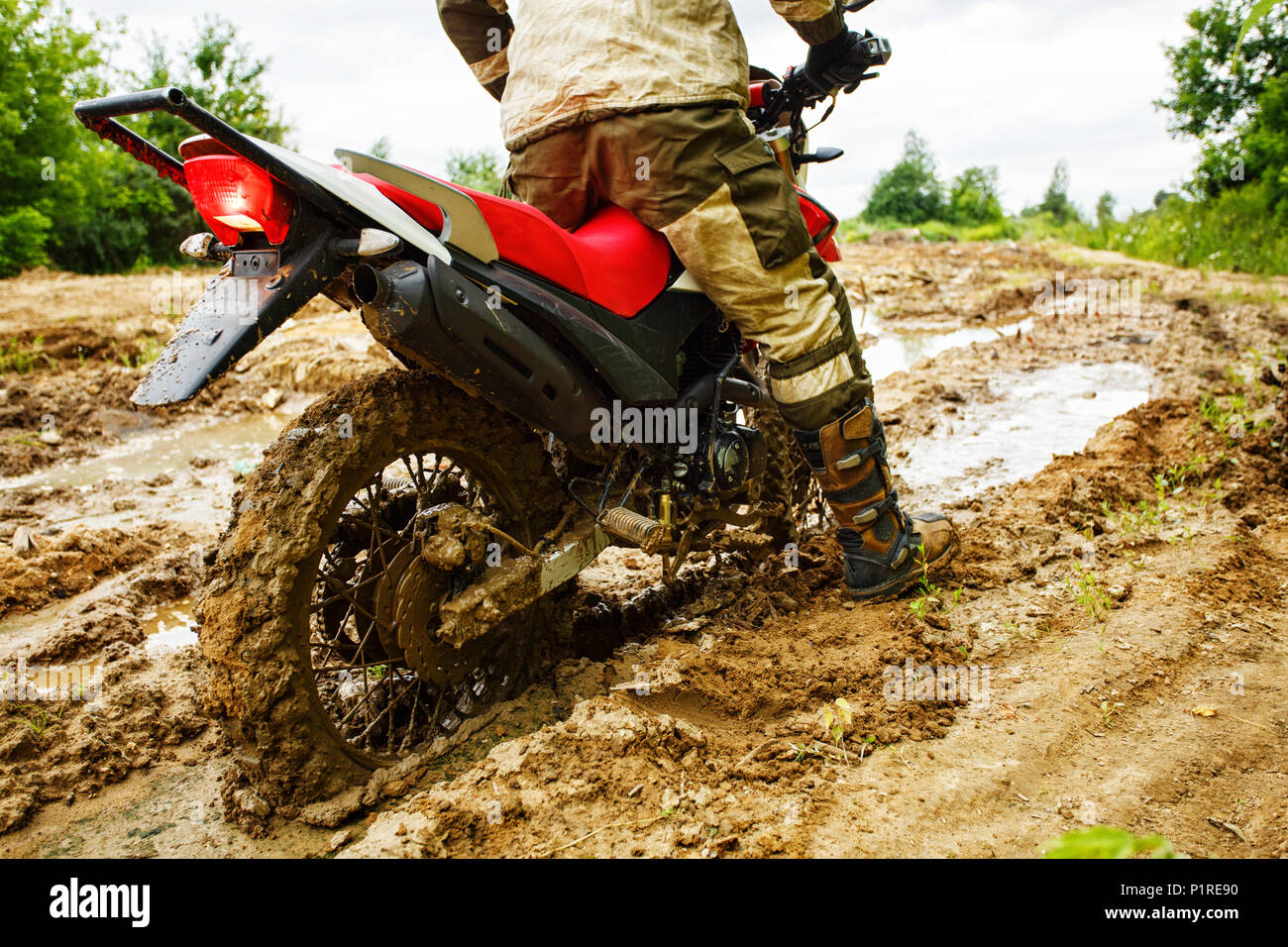 El hombre en una moto paseos a través del barro Fotografía de stock - Alamy