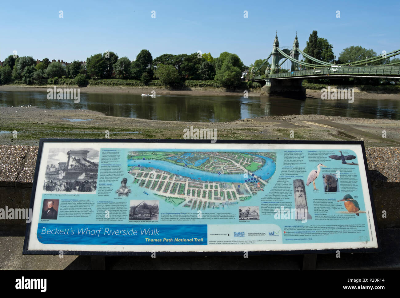 Información junta sobre beckett's Wharf Riverside Walk, frente al río Támesis anmd Hammersmith Bridge con marea baja. Foto de stock