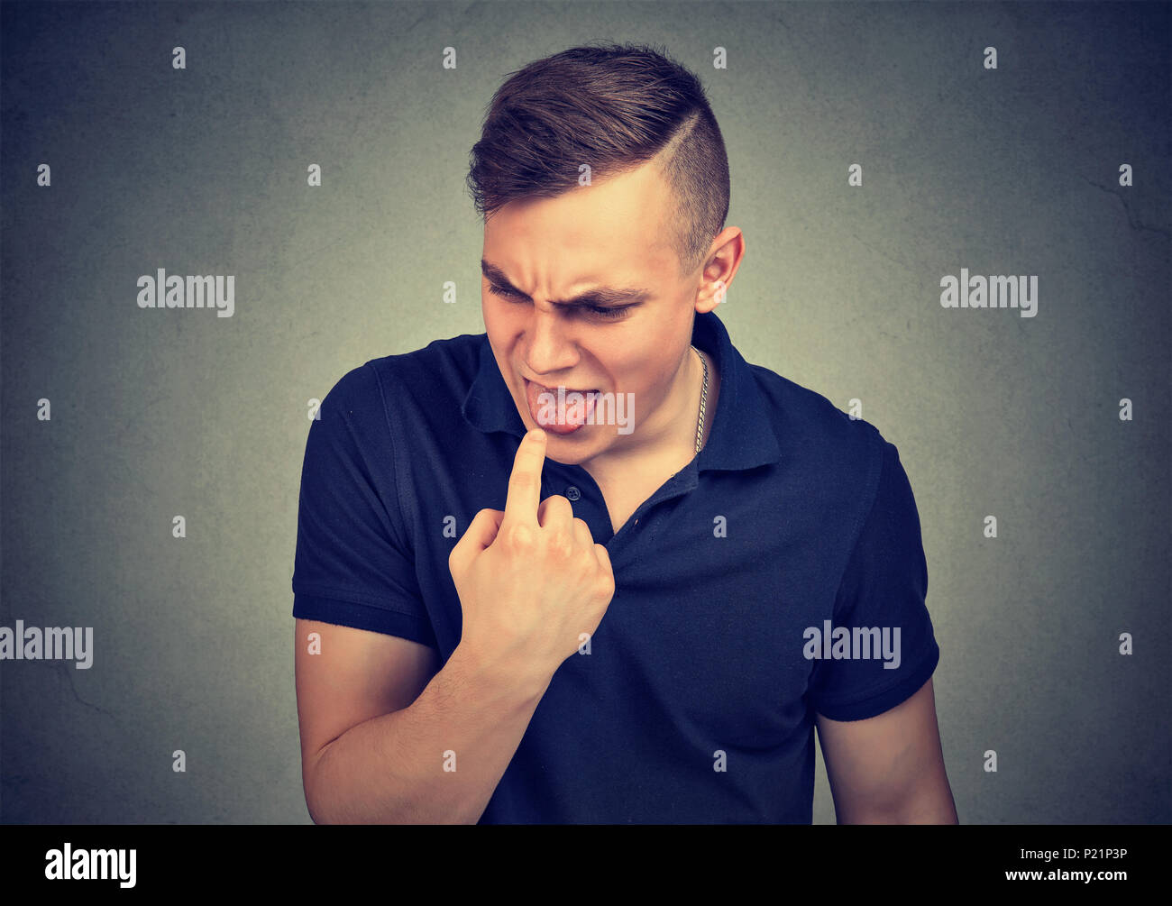 Disgustado el hombre con el dedo en la boca dispuesta a tirar hacia arriba Foto de stock