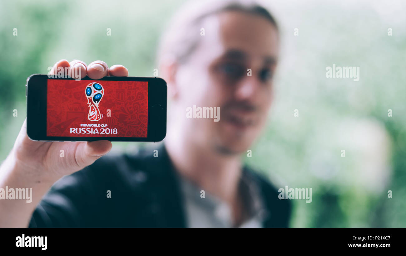 Primer plano de una joven sosteniendo iPhone blanco con FIFA WORLDCUP 2018 logotipo en la pantalla Foto de stock