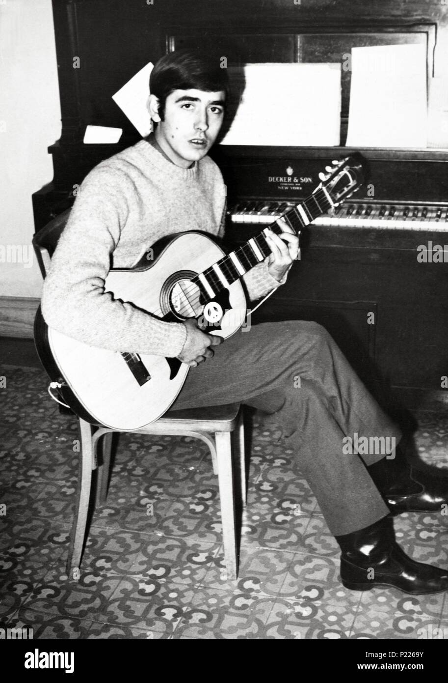 Joan Manuel Serrat en su piso de Poble Sec, Barcelona, tocando la guitarra.  1962 Fotografía de stock - Alamy