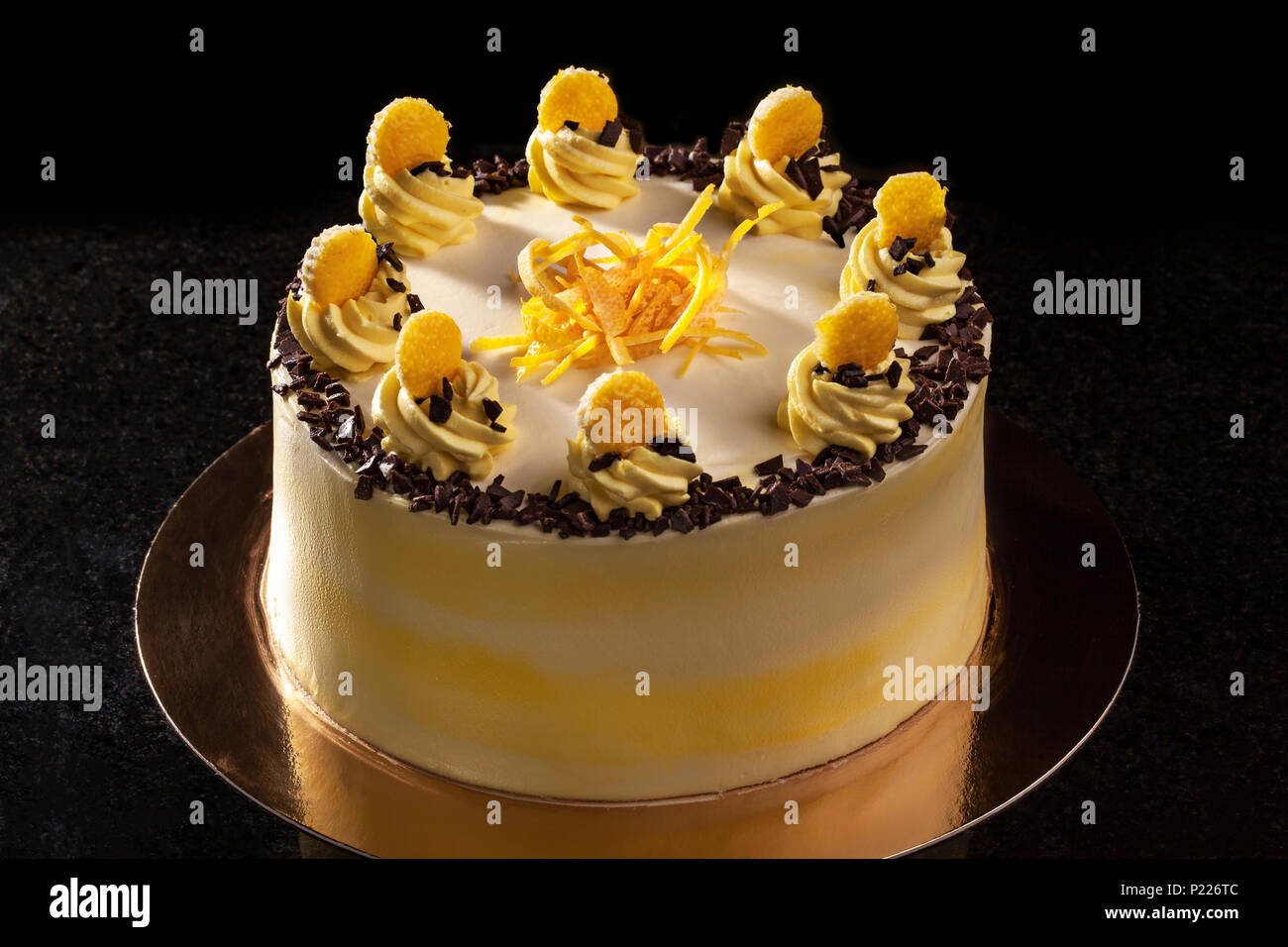 Redondo de color amarillo pastel de cumpleaños. Crema de decoración  decoración de la torta. Fondo negro Fotografía de stock - Alamy