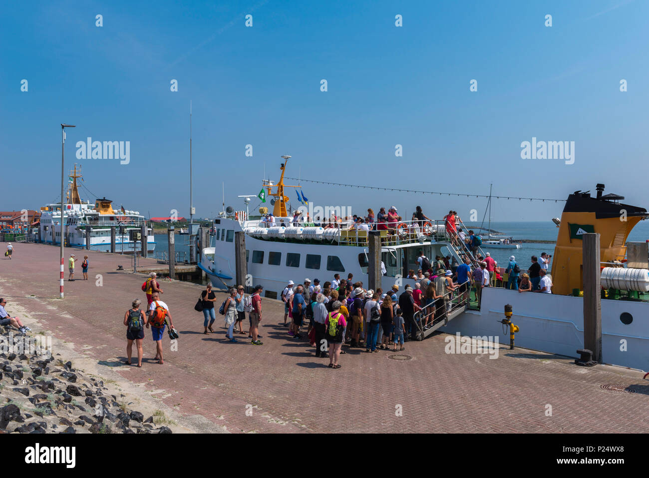 Los turistas entran en el ferry a la isla del Mar del Norte, Baltrum Neßmersiel, Frisia Oriental, Ostfriesland, Baja Sajonia, Niedersachsen, Deutschland Foto de stock