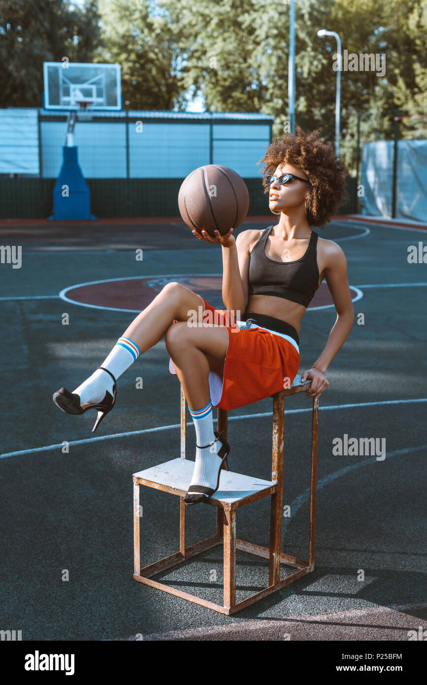 Joven Mujer afroamericana en vestimenta deportiva y tacones altos
