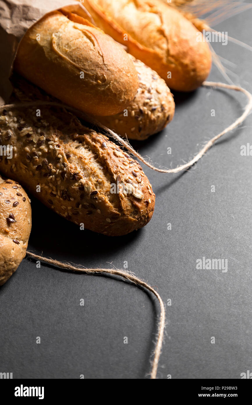 Diferentes pan fresco con semillas, sobre fondo negro. Útil como fondo baker Foto de stock