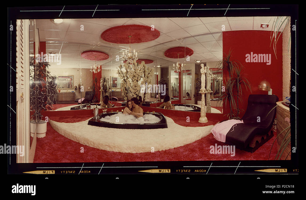. Inglés: una pareja se relaja en un baño de burbujas en Penn Hills Resort. La habitación cuenta con alfombra de lana y espejos del piso al techo. (El complejo cerrado en 2009). circa 1970. Penn Hills Resort 40 Penn Hills Resort, baño de burbujas, circa 1970 Foto de stock