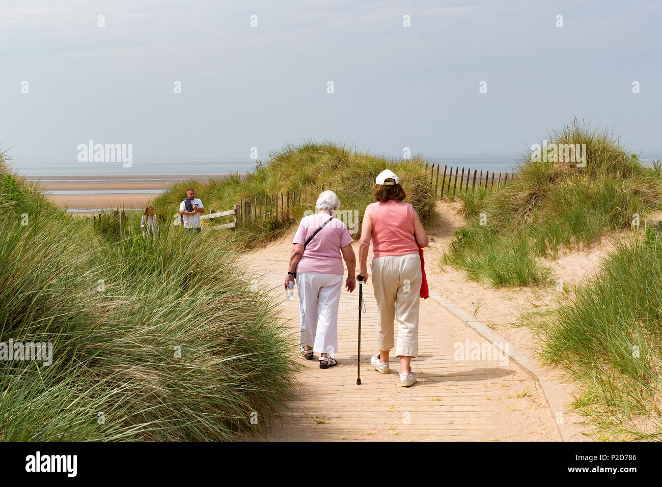 Dos altos señoras caminando por un sendero a la playa fomby cerca de Liverpool, Inglaterra, Gran Bretaña, Reino Unido, Foto de stock