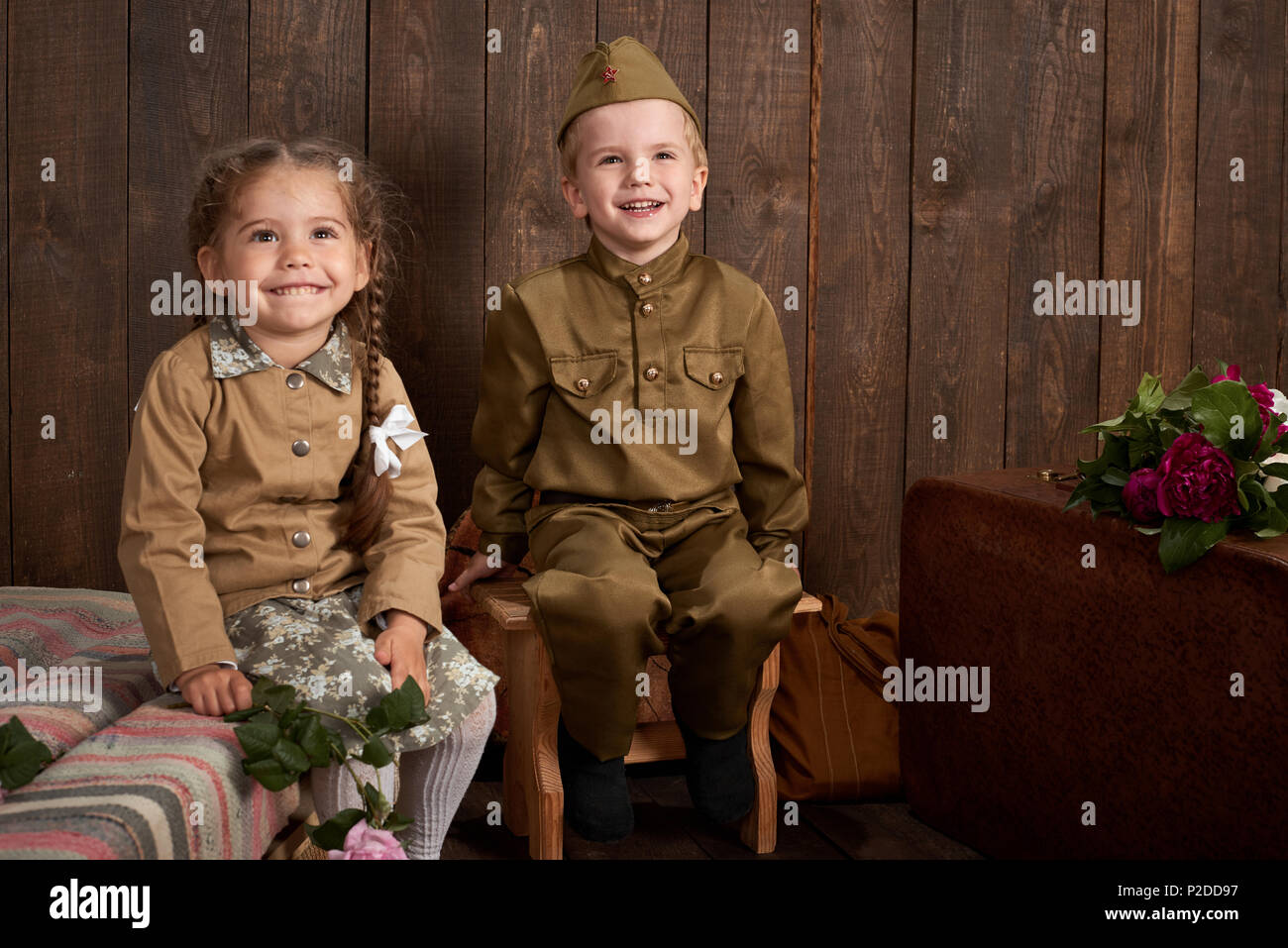 Los niños están vestidos en uniformes militares retro enviar un soldado del  ejército, de madera oscura de estilo retro de fondo Fotografía de stock -  Alamy