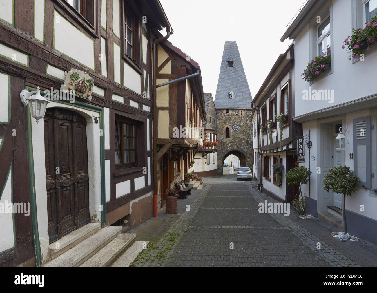 Casas con entramados de madera y la puerta de la torre del reloj del siglo XII en Herrstein, distrito administrativo de Birkenfeld, Región de Foto de stock