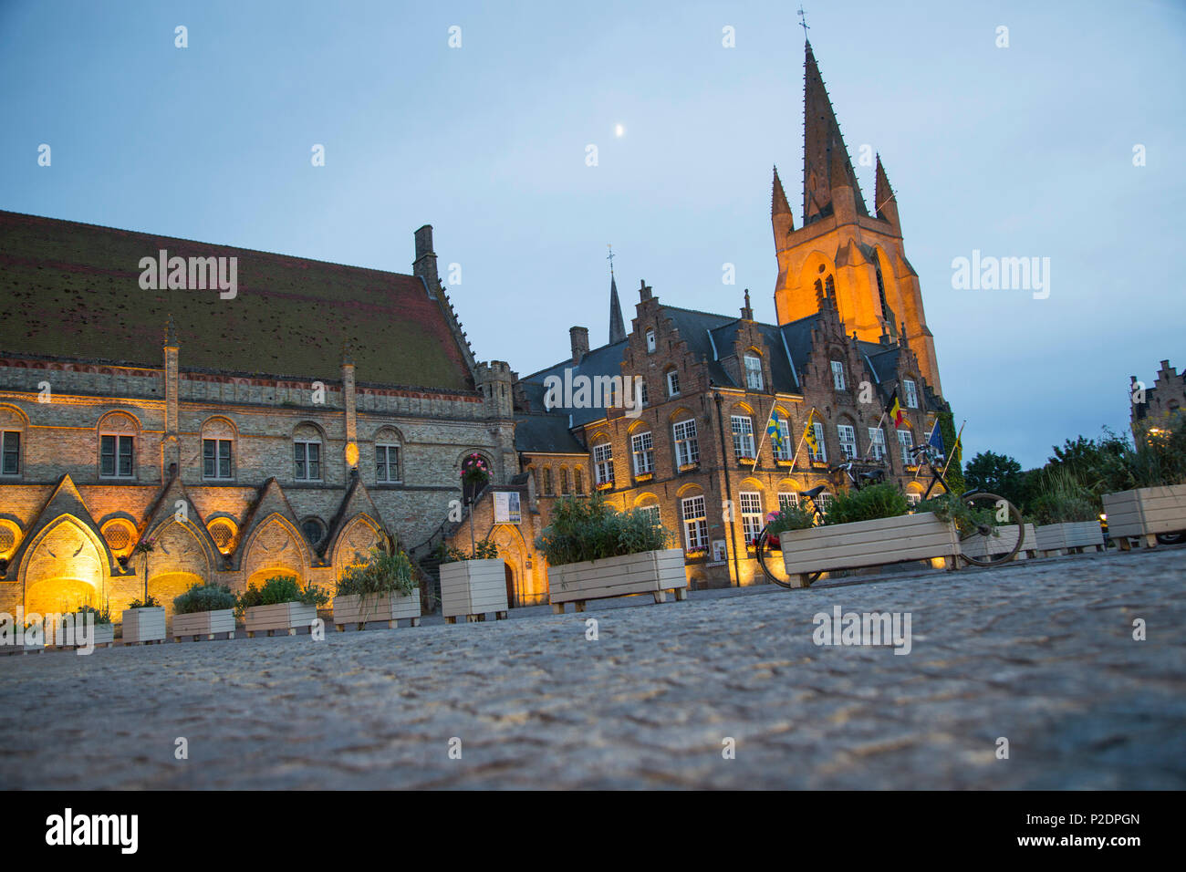Los adoquines de la plaza del mercado delante de Nieuwpoort el ayuntamiento y la iglesia al atardecer, Nieuwpoort, la Región de Flandes, Bélgica Foto de stock