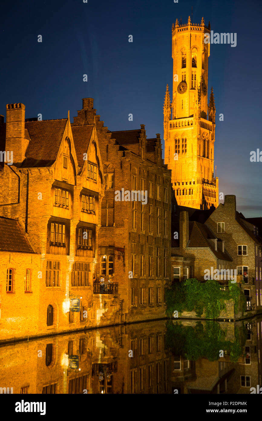 El Belfry y edificios iluminados durante la noche a lo largo del canal, en el centro histórico de la ciudad de brujas, brujas, Flandes, Bélgica Foto de stock