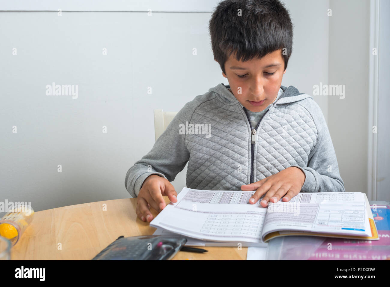 Surrey, UK-alumno de primaria trabajando en ejercicios de matemáticas Foto de stock