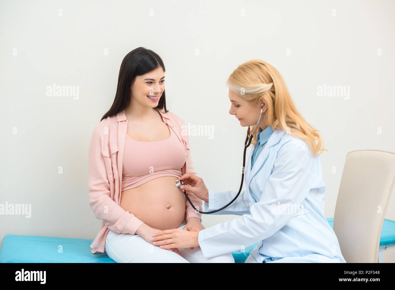 El obstetra ginecóloga escuchar latidos del corazón del feto de la mujer  embarazada del niño con un estetoscopio Fotografía de stock - Alamy