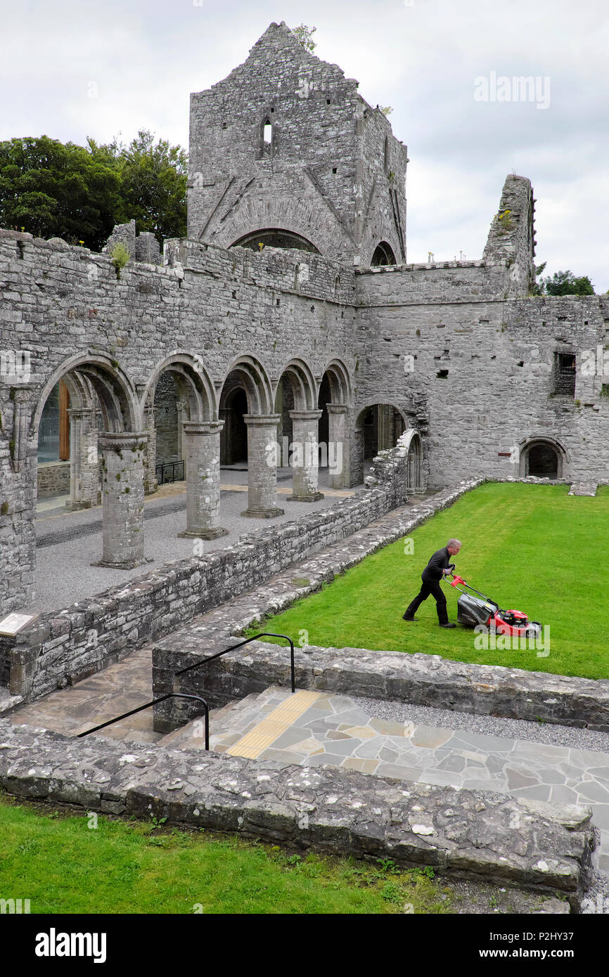Un hombre viejo / Portero / conserje siega el césped, Abadía Boyle, Sycamore Crescent, Boyle, del Condado de Roscommon, Irlanda Foto de stock