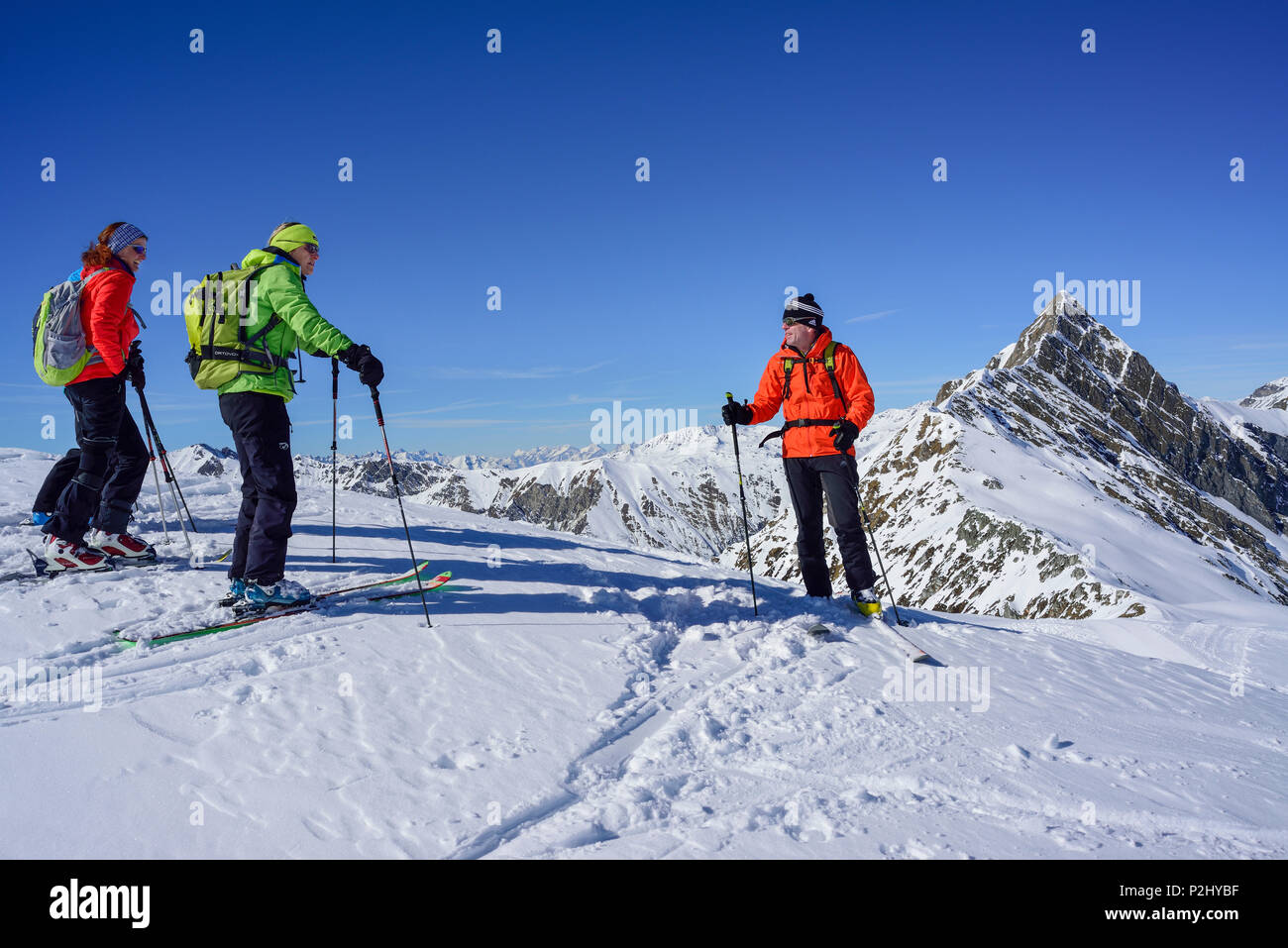 Varias personas volver de esquí tras un descanso, en el fondo, Frauenwand Hornspitze, valle de Schmirn, Zillertal Alps, Tyr Foto de stock