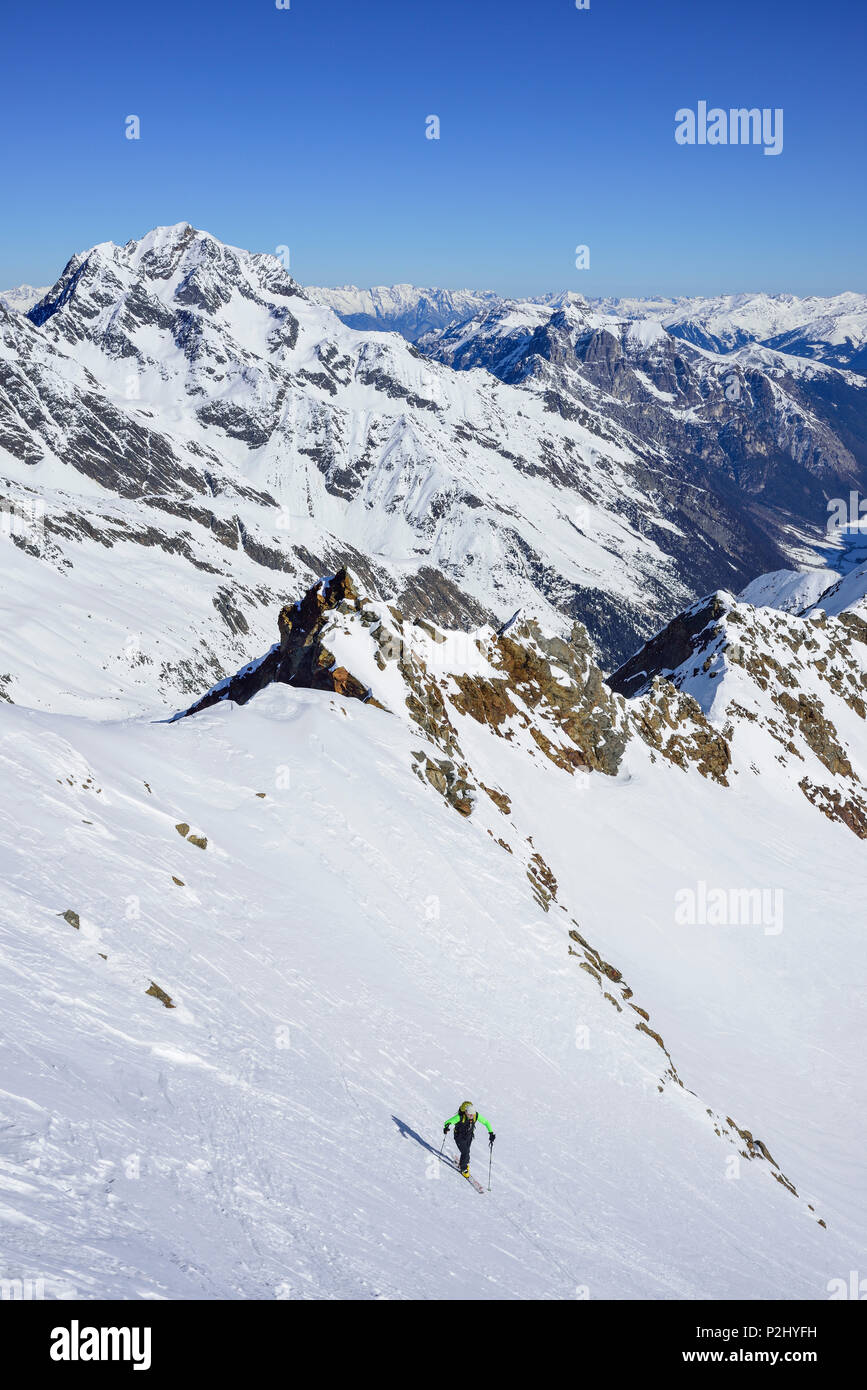Hombre de esquí ascendiendo hacia Schneespitze Habicht, en el fondo, Schneespitze, valle de Stubai, Pflersch Alpes Foto de stock