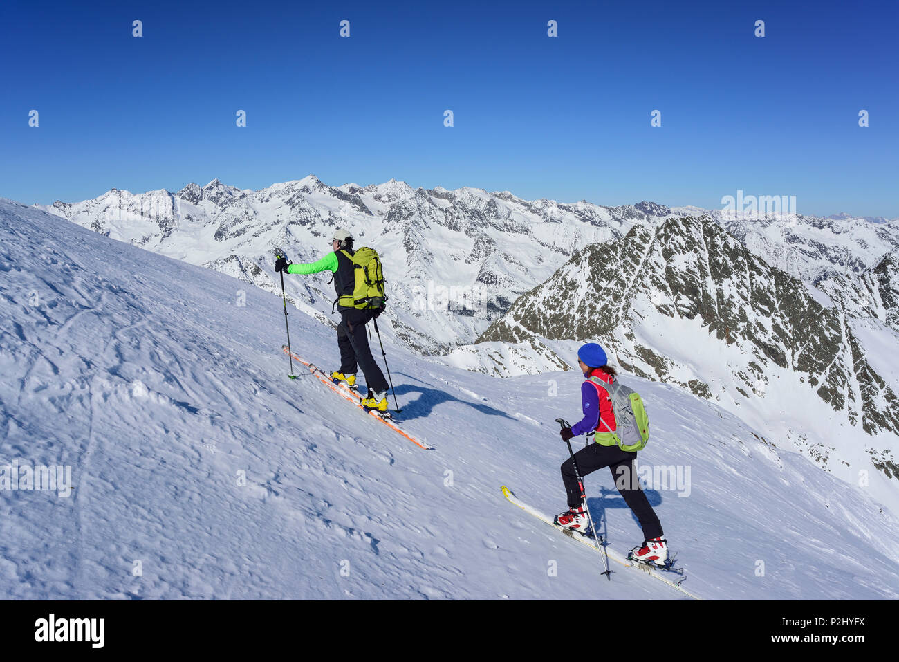 Hombre y mujer de regreso de esquí ascendiendo hacia Schneespitze, Pflersch Schneespitze, valle de Stubai, Alpes, Tirol del Sur, Foto de stock