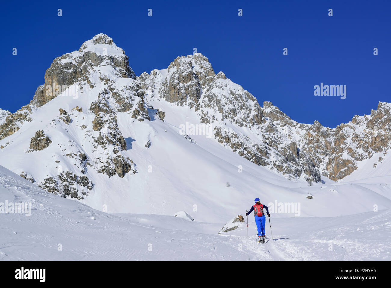 Mujer de regreso de esquí ascendente a Col Monte Sautron Sautron, en el fondo, Col Sautron, Valle Maira, Alpes, Piedmon Cottian Foto de stock