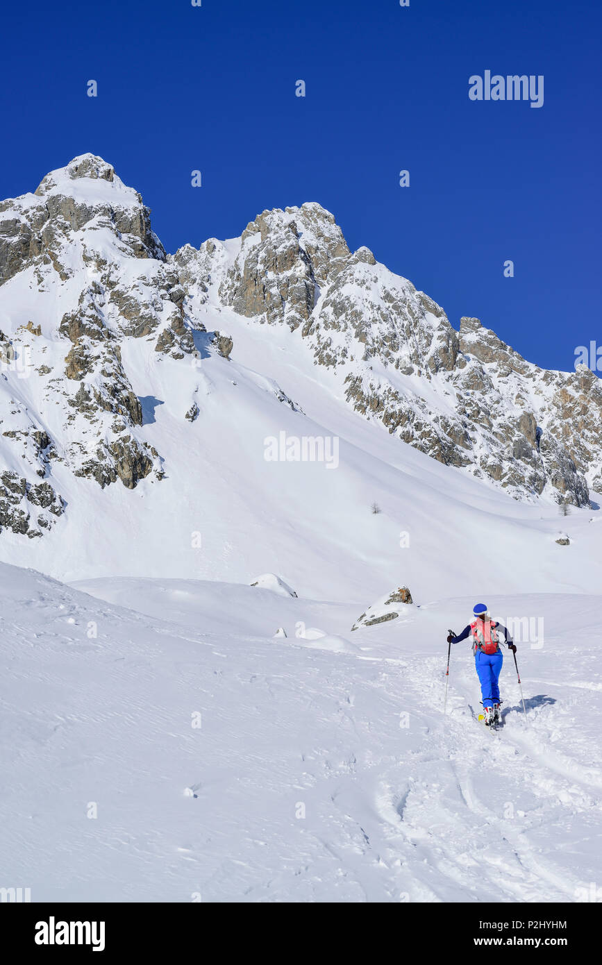 Mujer de regreso de esquí ascendente a Col Monte Sautron Sautron, en el fondo, Col Sautron, Valle Maira, Cottian Alpes, circulares Foto de stock