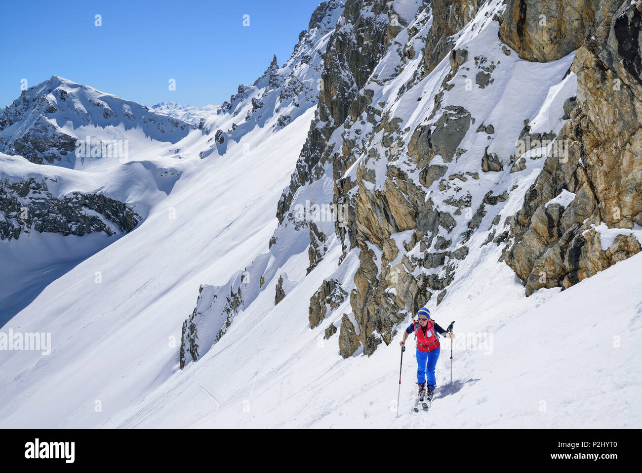 Mujer de regreso de esquí ascendente a la Monte Viraysse Forcellina, en el fondo, Col Sautron, Valle Maira, Cottian Alpes. Foto de stock