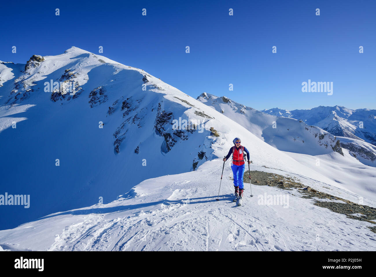 Mujer de regreso de esquí en Col Sautron permanente, en el Monte de fondo y Tete Peymian Viraysse, Col Sautron, Valle Maira, Foto de stock