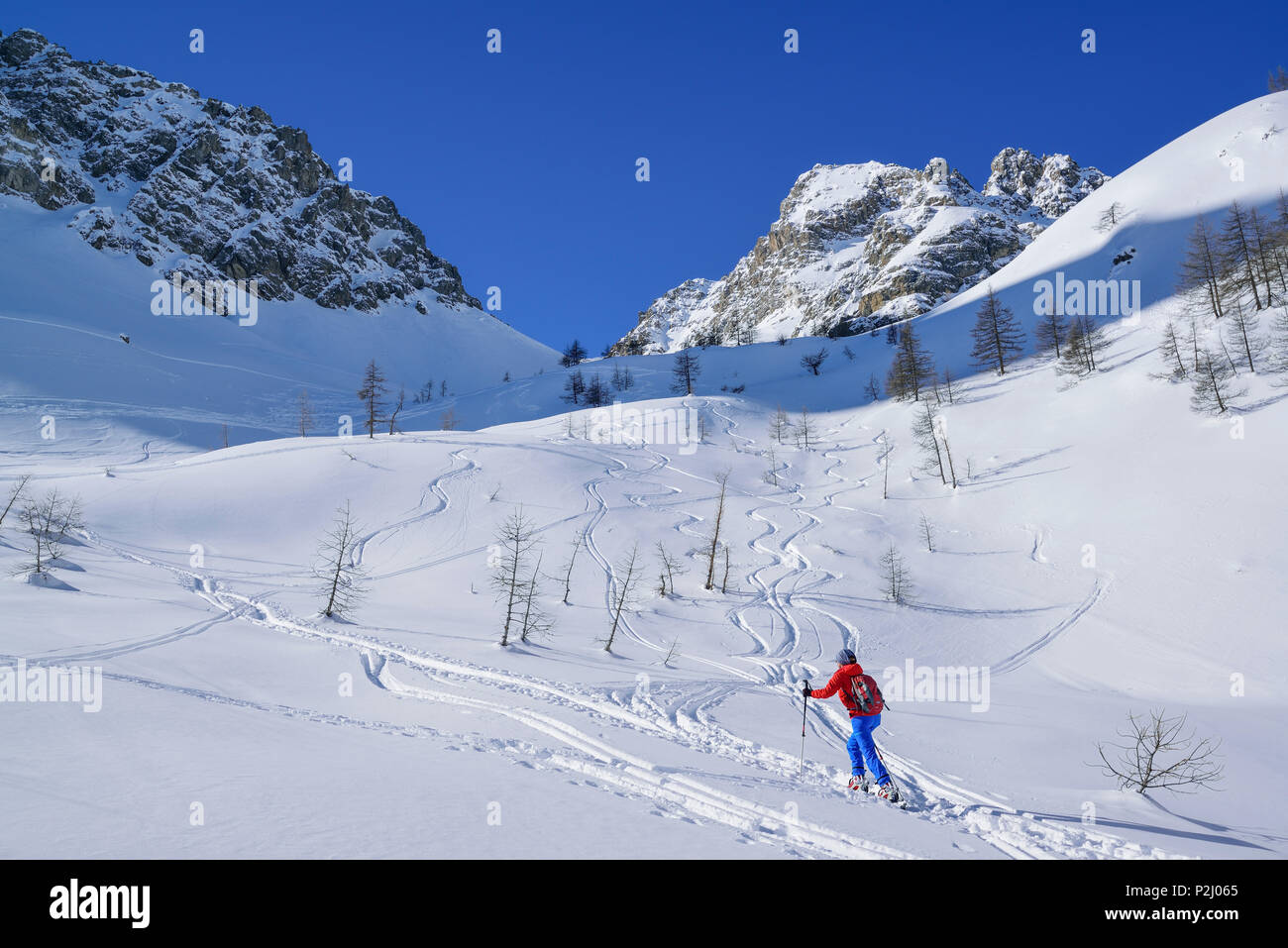 Mujer de regreso de esquí ascendente a Passo Croce, Rocca Peroni en el fondo, el Passo Croce, Valle Maira, Cottian Alpes, Pied Foto de stock