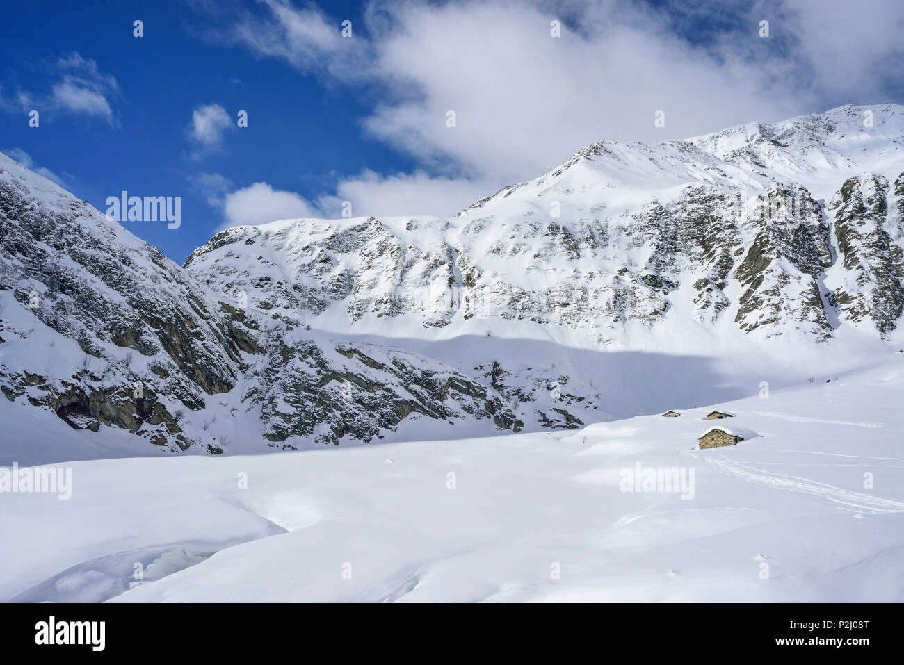 Paisaje invernal con cabañas alpinas cubiertas de nieve, Monte, Valle Varaita Faraut, Cottian Alpes, Piamonte, Italia Foto de stock