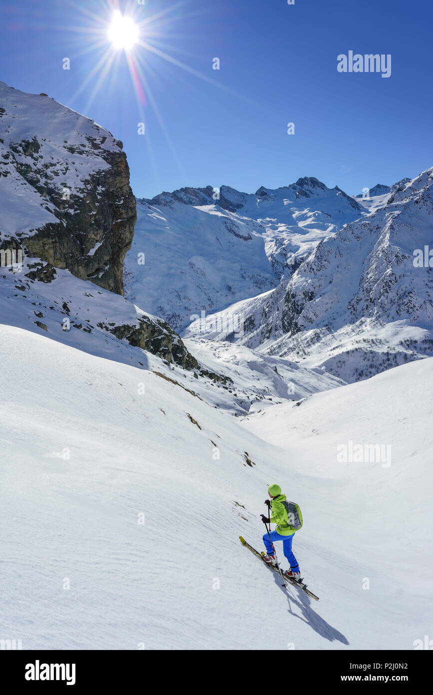 Mujer de regreso de esquí ascendiendo hacia el Monte Salza, en el fondo, el Monte Salza Senghi Rocca, Valle Varaita, Cottian Alp Foto de stock