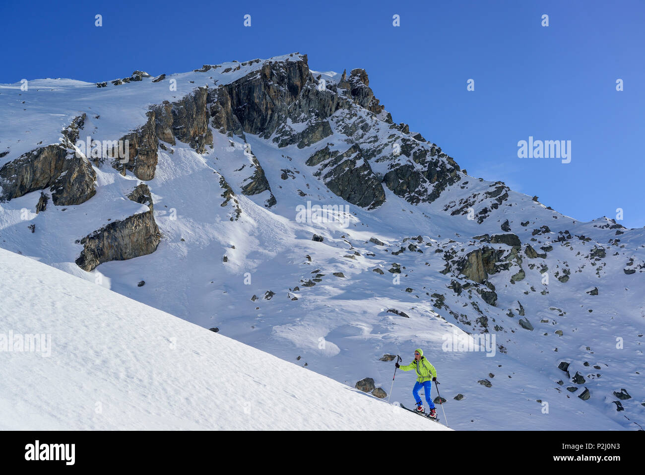 Mujer de regreso de esquí ascendiendo hacia el Monte Salza, Monte Salza, Valle Varaita, Cottian Alpes, Piamonte, Italia Foto de stock