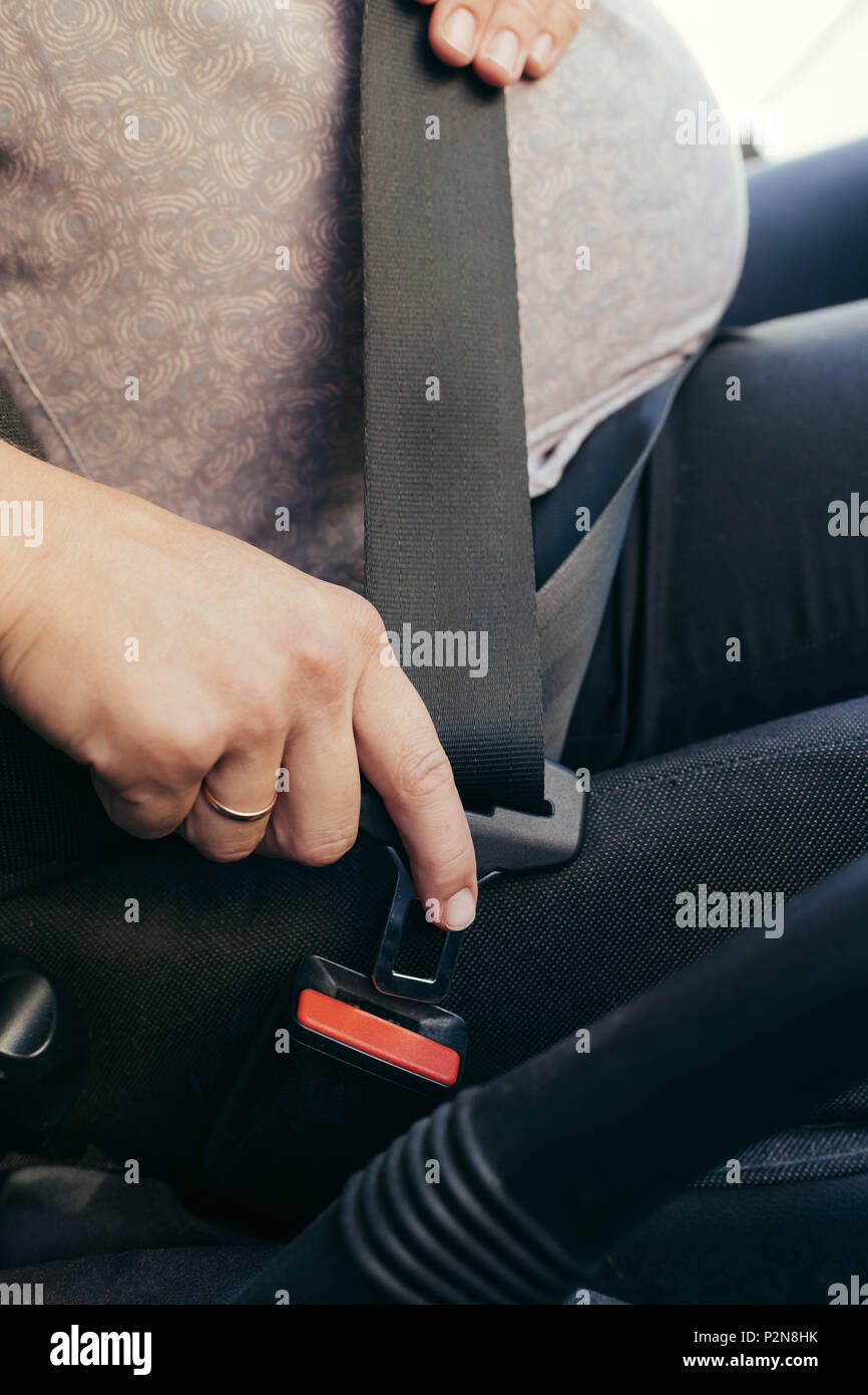 La mujer embarazada en el coche usando el cinturón de seguridad, vista  lateral Fotografía de stock - Alamy