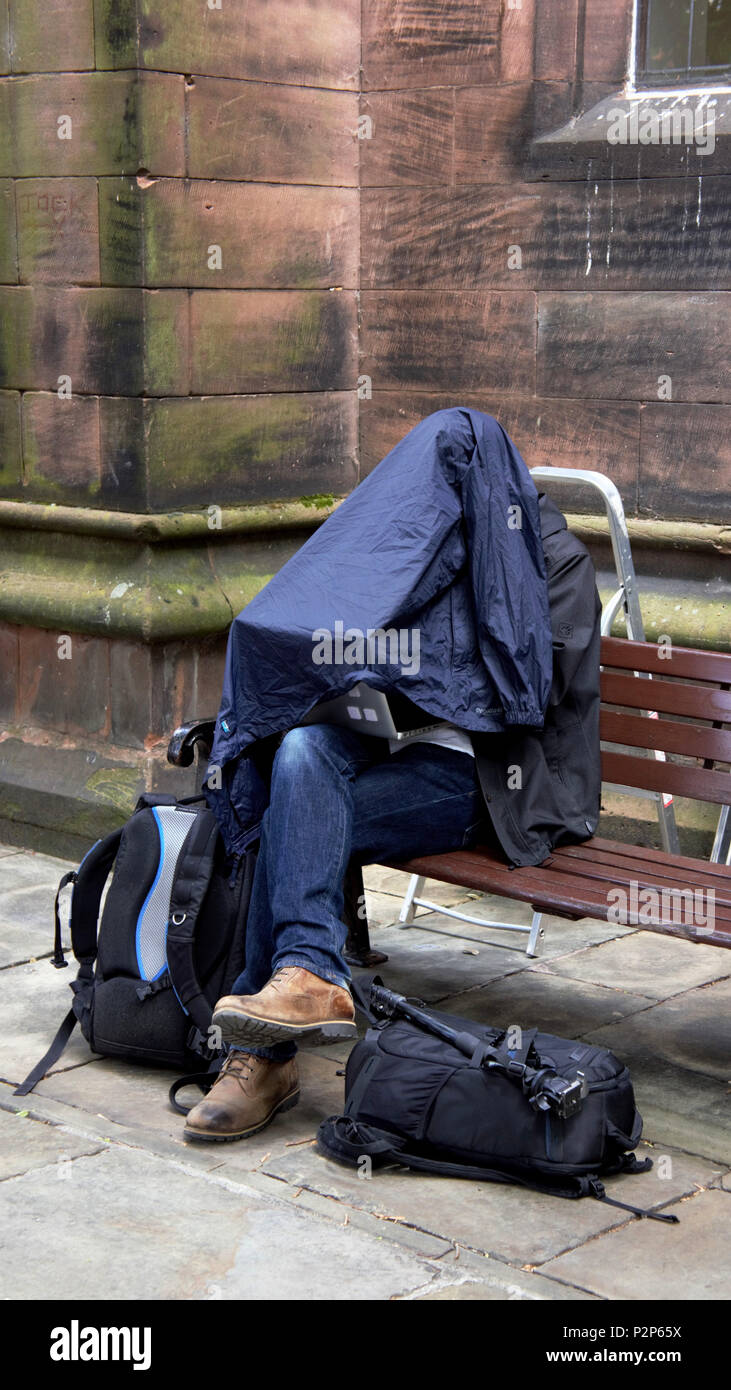 No uno de Chester's en la calle, pero un fotógrafo de prensa trabaja duro analizando su día de trabajo. Foto de stock