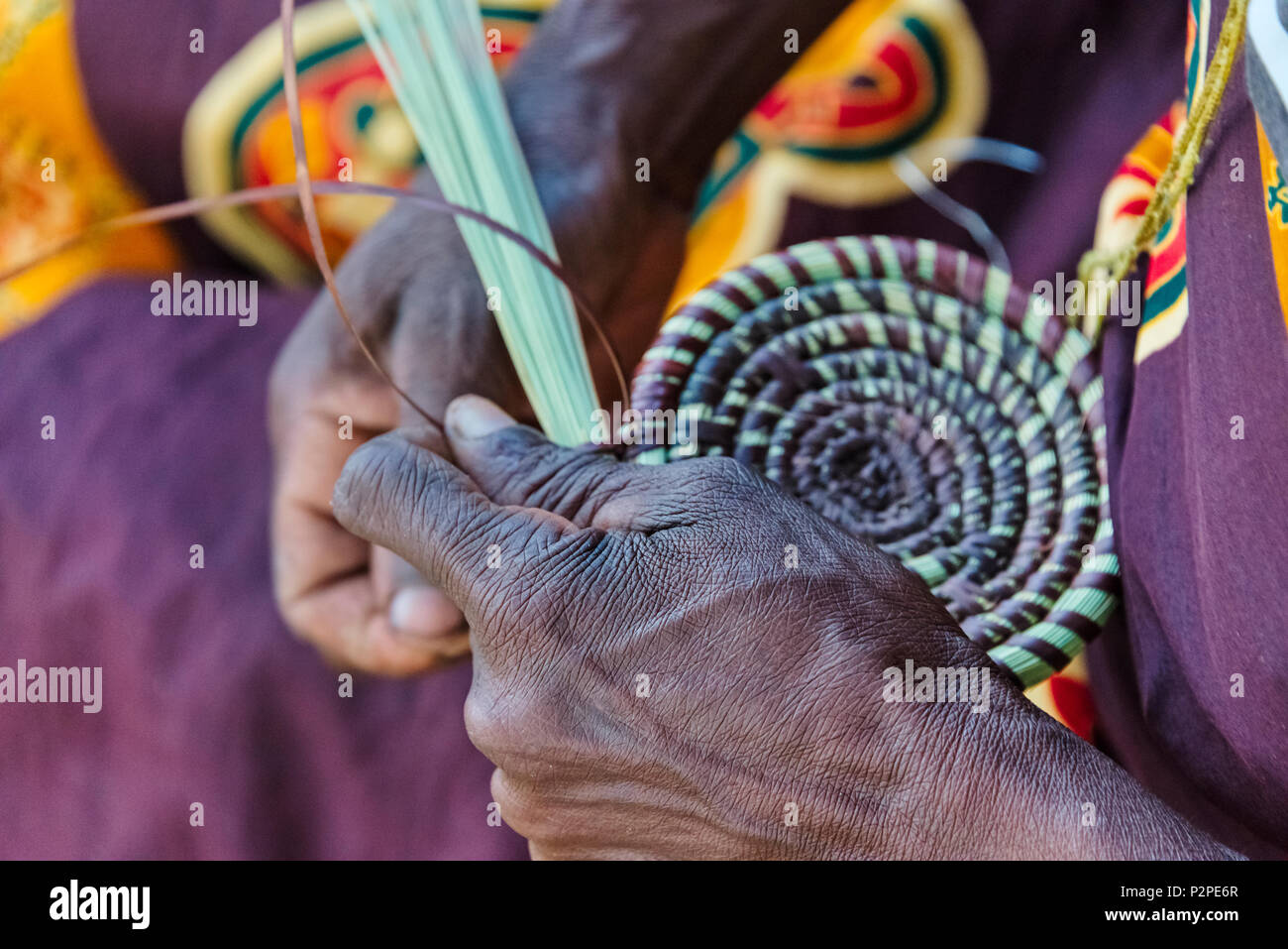 Tribu Mbukushu Mujer tejiendo cojín de pasto, Kwando tradicional aldea, Región Zambezi, Namibia Foto de stock