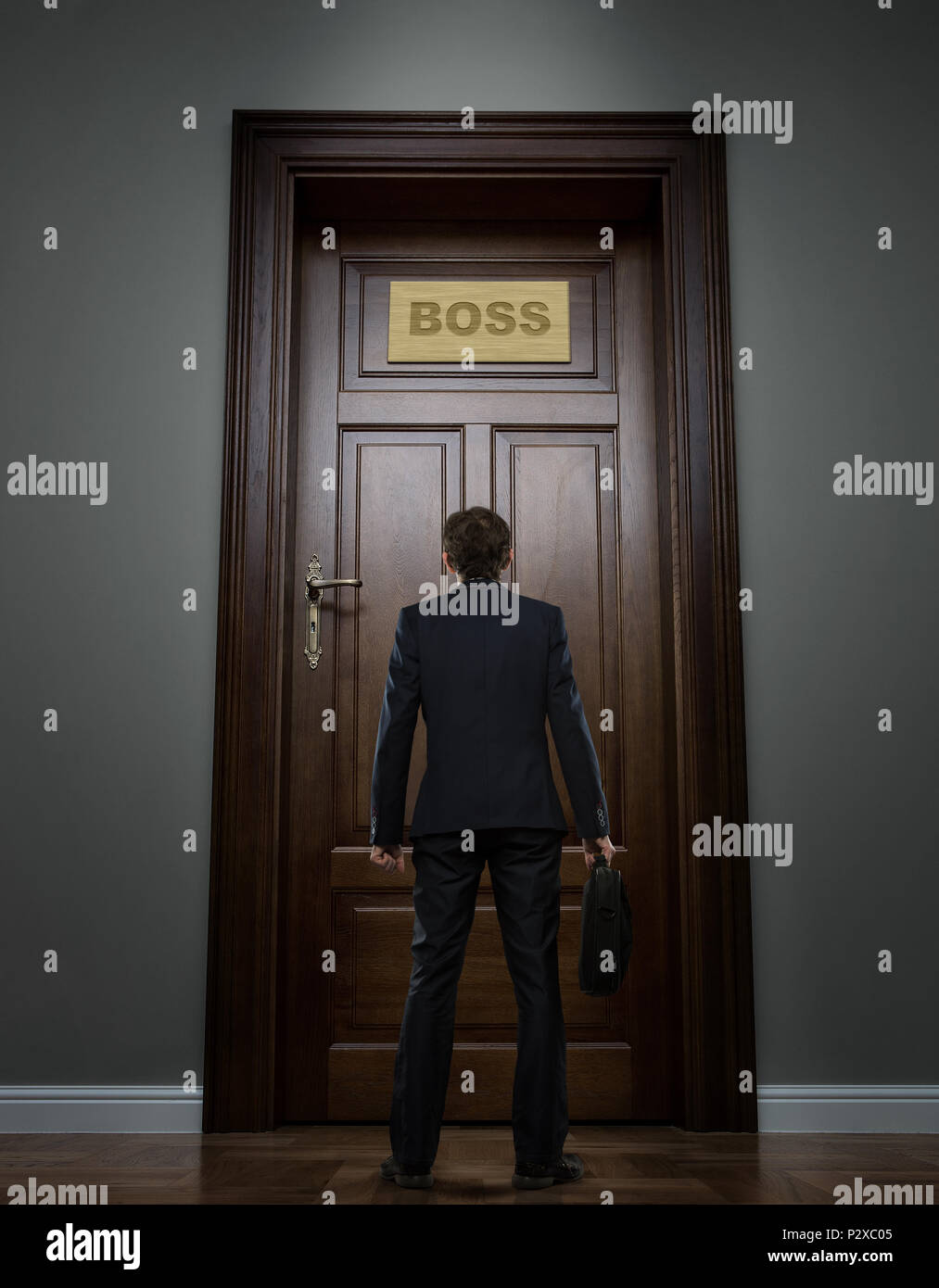 Pequeño empresario joven de pie delante de la puerta de la oficina boss Foto de stock