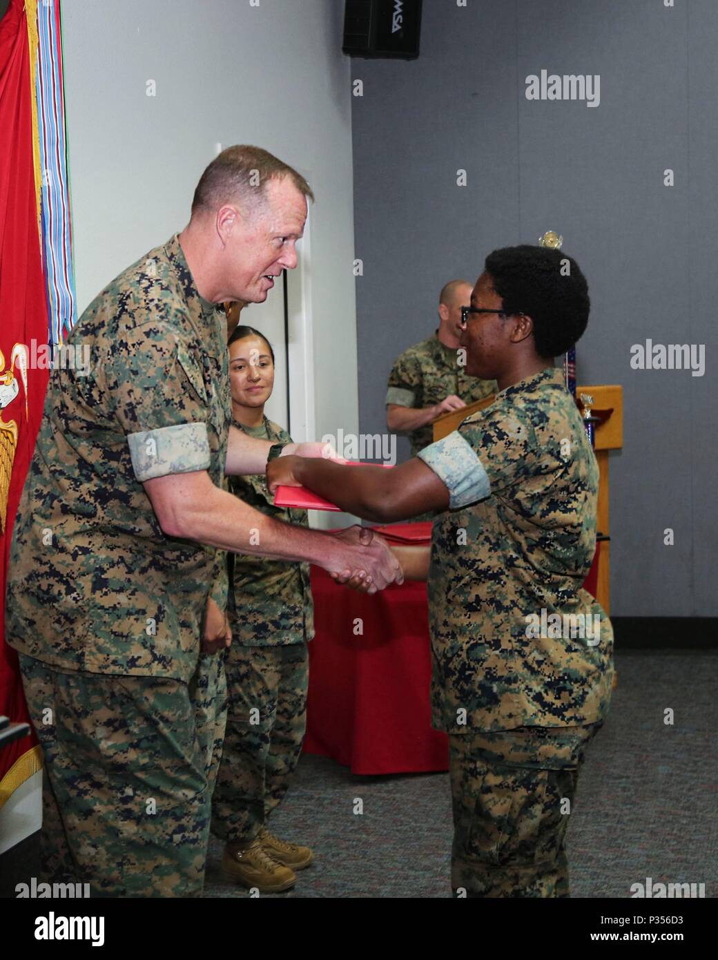 Gral. Gen. Mark R. Wise, comandante general de la 3ª ala de avión Marino,  presenta un certificado de felicitación del Sgt. Madison J. Benjamin, un  planificador profesional de la Sede ala Marina