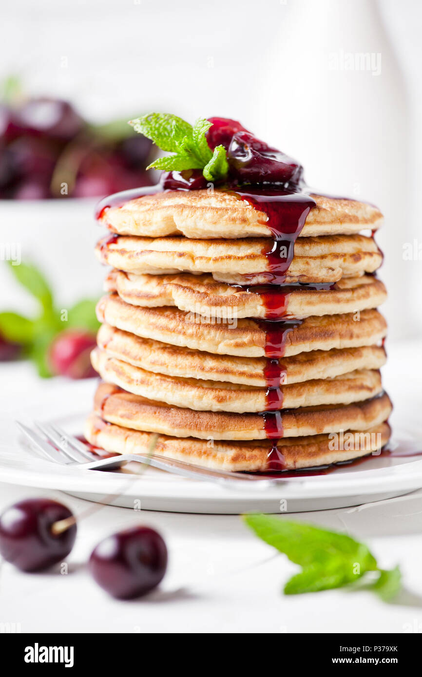 Montón de tortitas caseras con cherry topping Foto de stock
