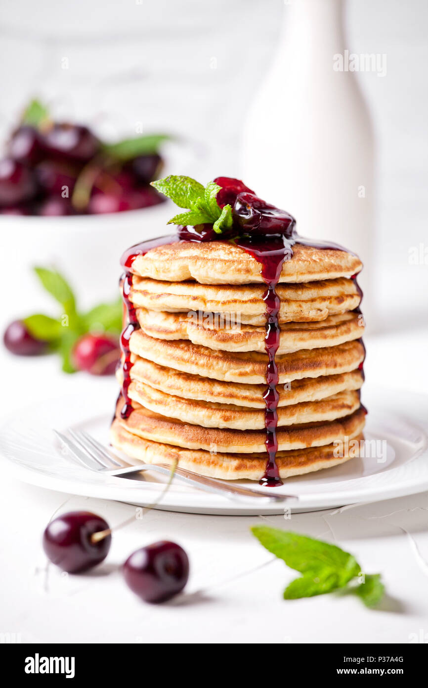 Montón de tortitas caseras con cherry topping Foto de stock