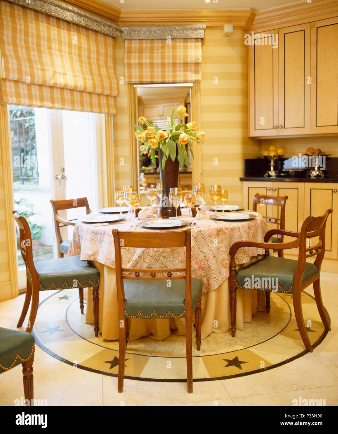 Sillas antiguas tapizadas en mesa circular con telas paño de cocina en la  casa marcada con amarillo persianas Fotografía de stock - Alamy
