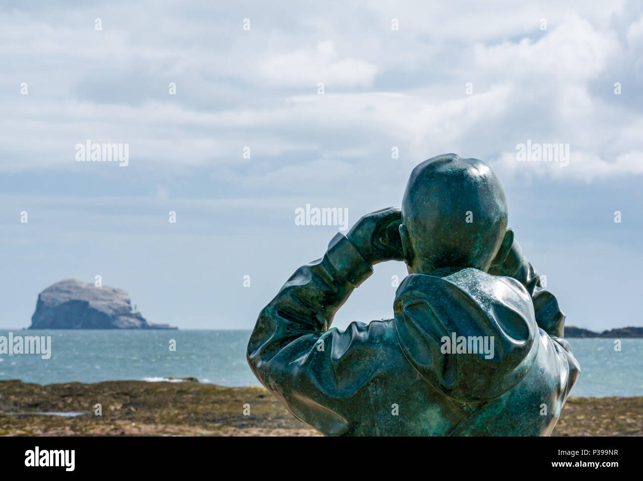 Milsey Bay, North Berwick, East Lothian, Escocia, Reino Unido, 18 de junio de 2018. Una estatua de bronce de tamaño natural llamado el observador por el escultor Kenny Hunter mira a la colonia de alcatraces Bass Rock, la mayor colonia de alcatraces del norte Foto de stock