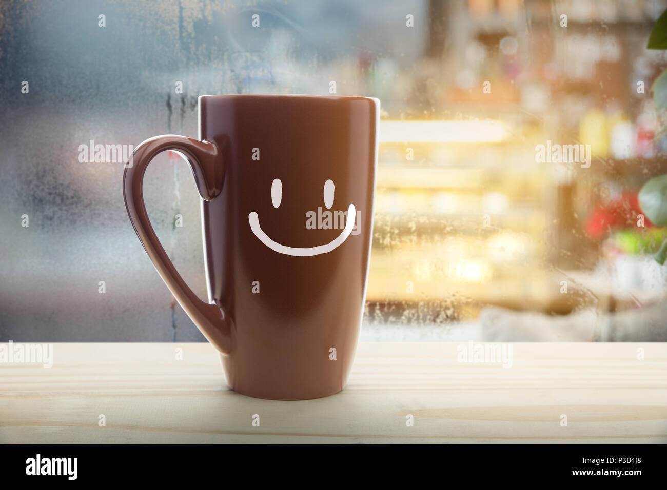 Brown taza de café con una feliz sonrisa, roja humeante taza de café en un  día lluvioso de fondo de la ventana, buenos días o tener un día feliz  concepto de mensaje