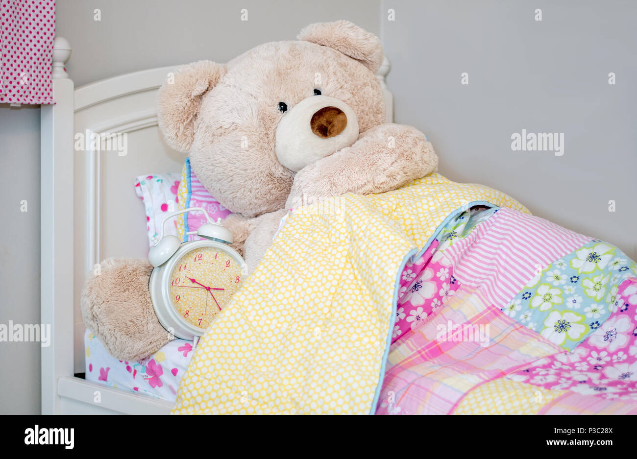 Un oso muy grande sube a la cama con su reloj despertador gigante. buenas  noches! Fotografía de stock - Alamy