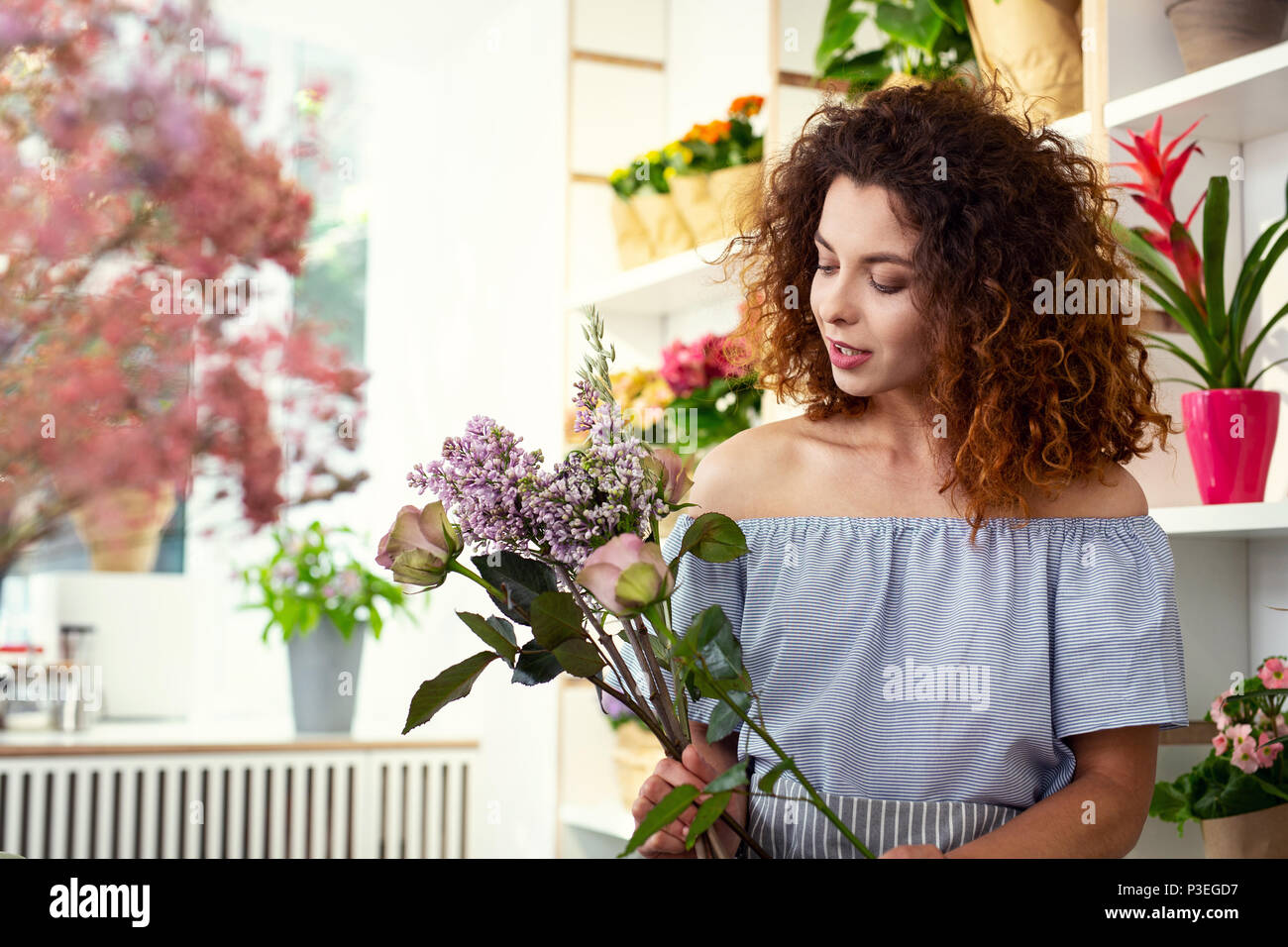 Creative agradable mujer mirando las flores Foto de stock