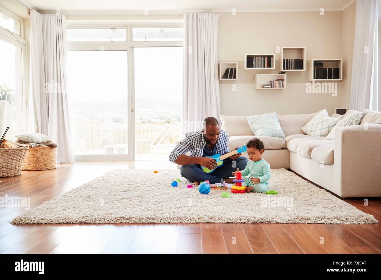 Padre negro y un hijo pequeño jugando en la sala de estar Foto de stock
