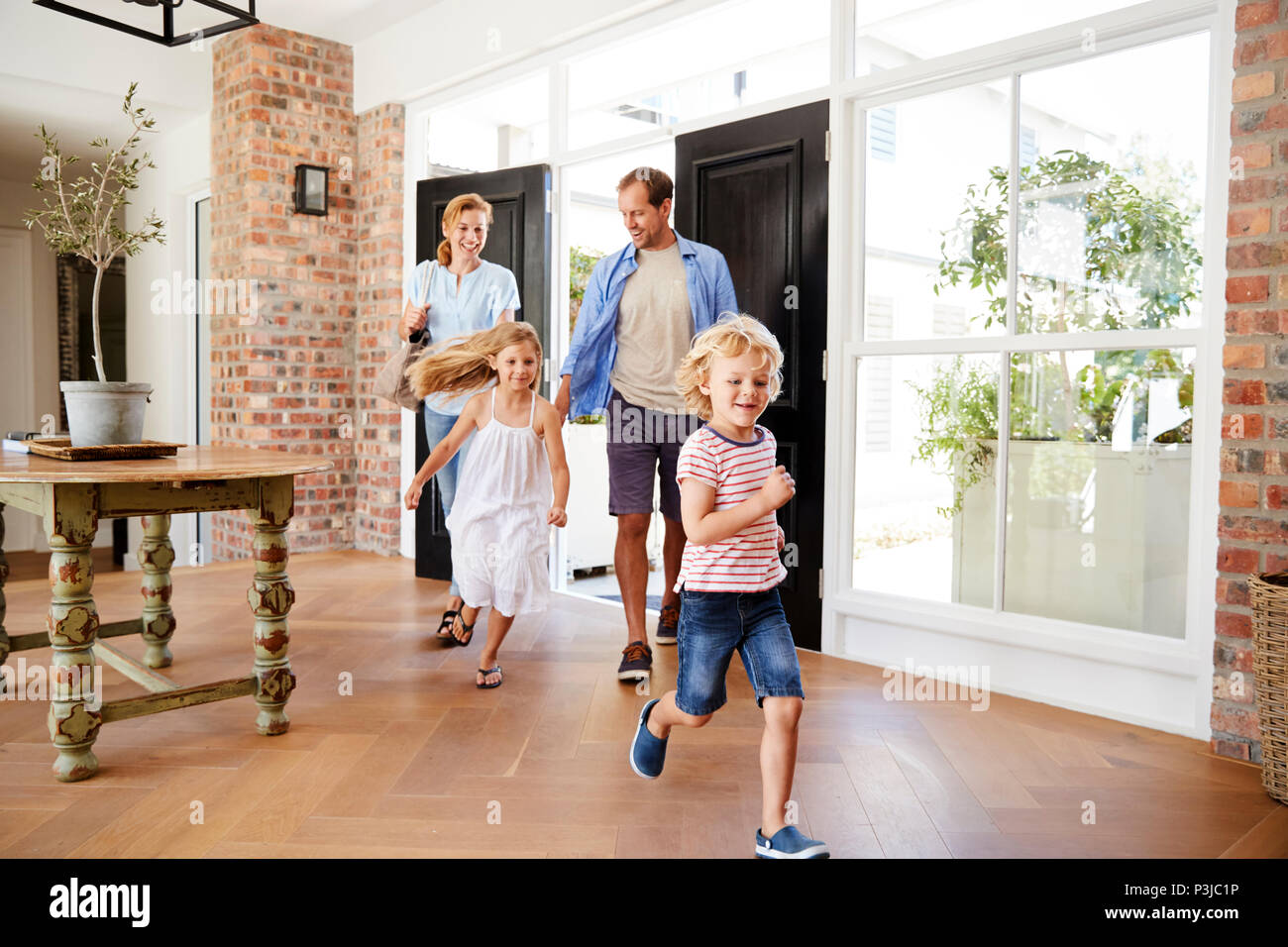 Familia joven llega a su casa Fotografía de stock - Alamy