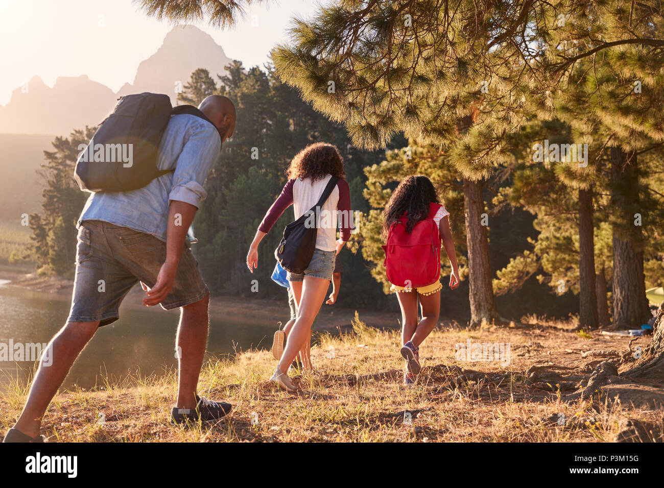 Los niños caminan por el lago con padres de familia Aventura Senderismo Foto de stock