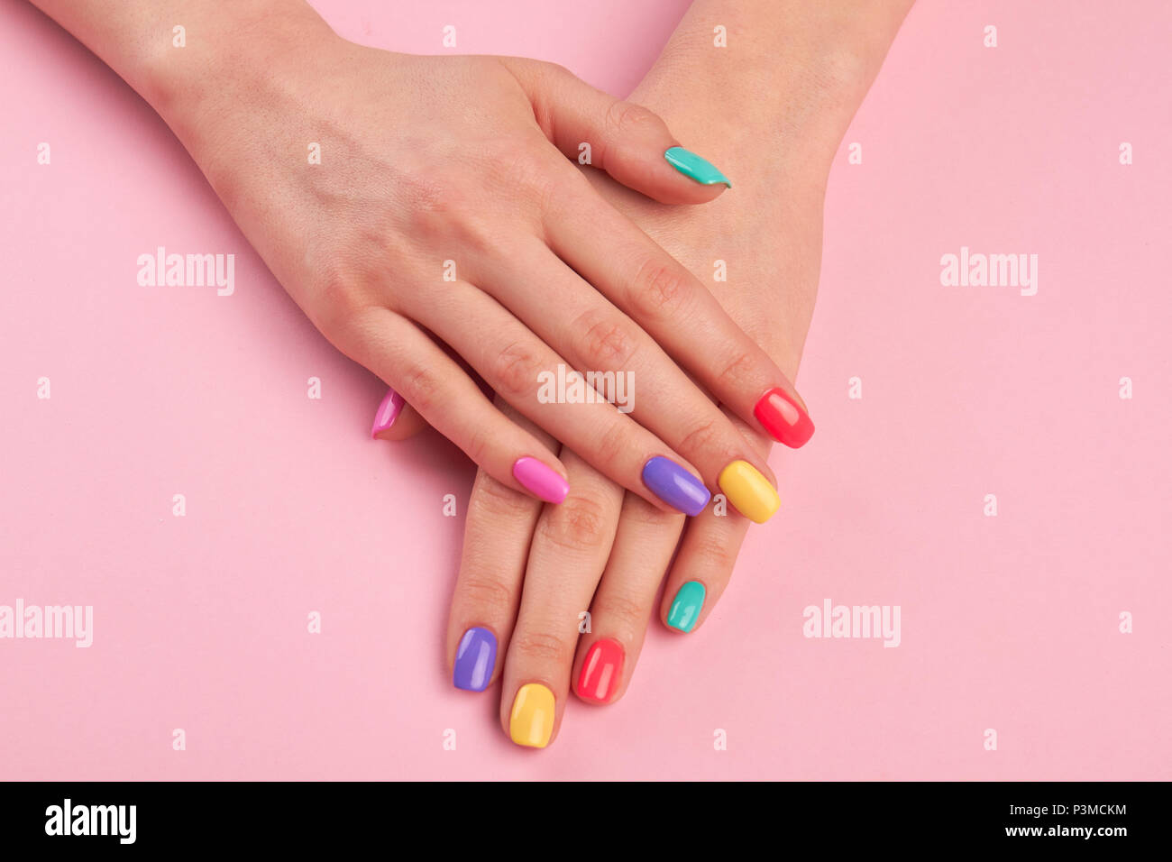 Manos femeninas con coloridos pulir uñas. Foto de stock