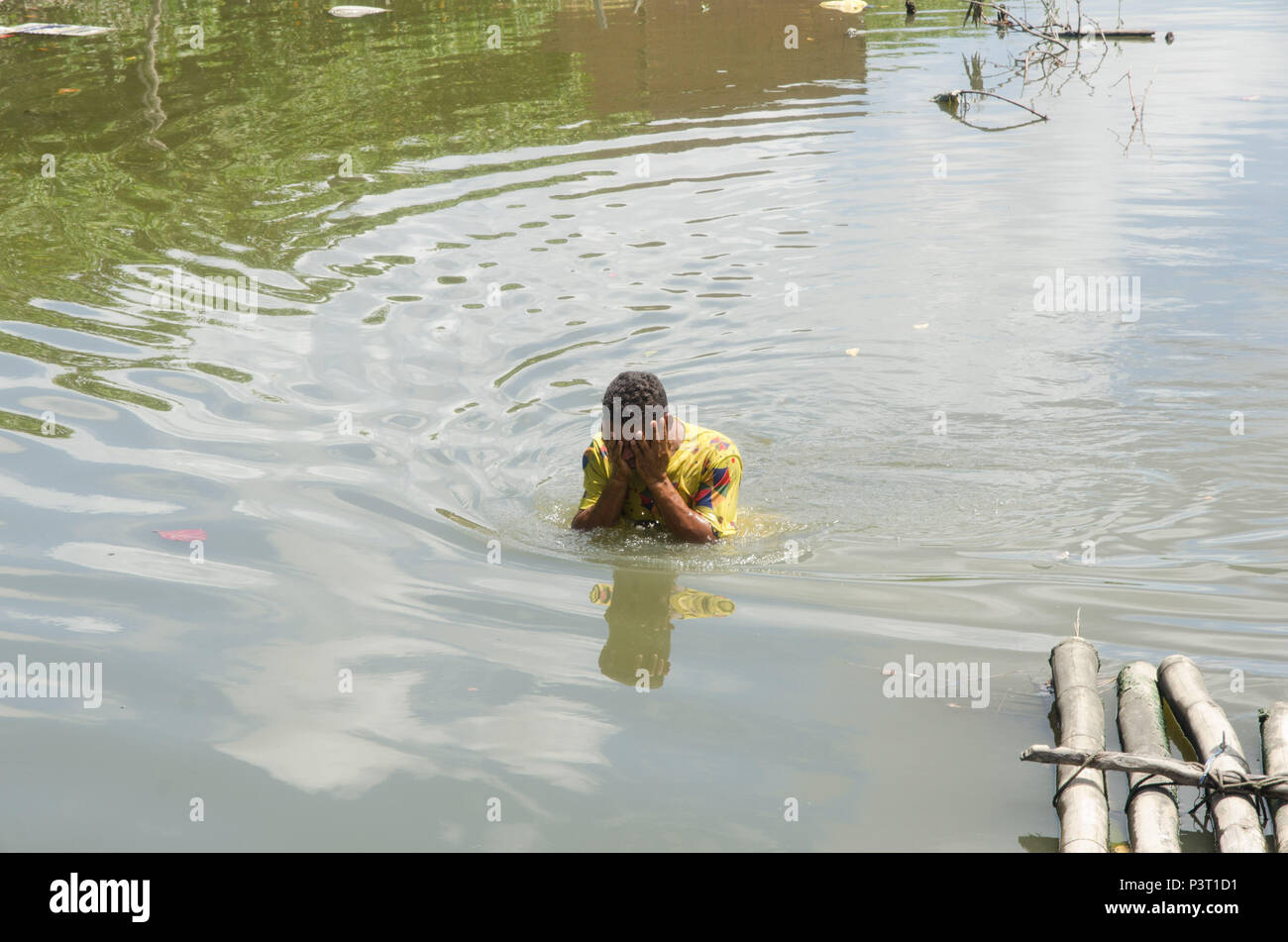 RECIFE, PE - 20.10.2015: FAVELA DO NO BUEIRO RECIFE - Homem tomando banho ningún río Capibaribe, na favela do Bueiro, no Recife (PE). (Foto: Diego Herculano / Fotoarena) Foto de stock
