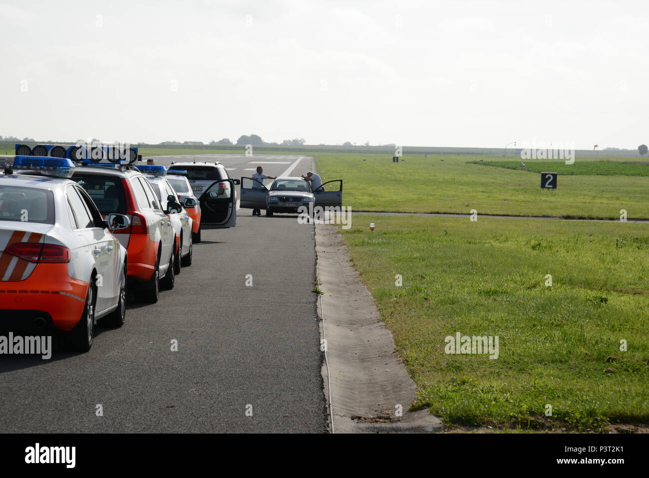 La línea de vehículos de la policía para realizar la calibración del  velocímetro en la pista de aterrizaje de la Base Aérea de Chièvres, Martes,  26 de julio de 2016. Chièvres Policía