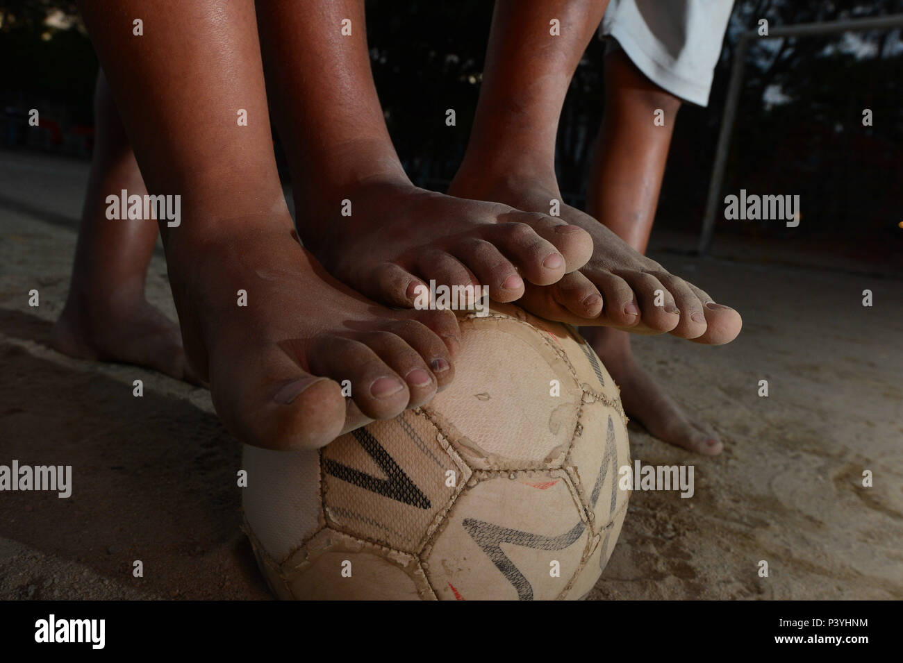 Crianças da Comunidade carente de Rio das Pedras na zona oeste do rio , com os Pés sujos de terra batida sobre uma bola de futebol. Foto de stock